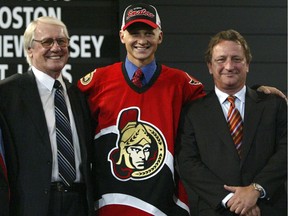 Brian Lee stands between John Muckler, then Senators GM, and owner Eugene Melnyk after being drafted ninth overall in Ottawa in 2005.