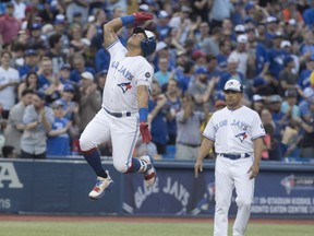 Toronto Blue Jays Yangervis Solarte jumps in the air rounding third base as coach Luis Rivera looks on after hitting a home run against the Washington Nationals on Friday. (THE CANADIAN PRESS)