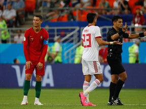 Portugal's Cristiano Ronaldo (left) reacts to receiving a yellow card during Monday's game against Iran. (GETTY IMAGES)