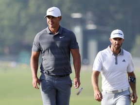 Brooks Koepka of the United States and Dustin Johnson of the United States walk off on the 18th green during the final round of the 2018 U.S. Open at Shinnecock Hills Golf Club on June 17, 2018 in Southampton, New York.