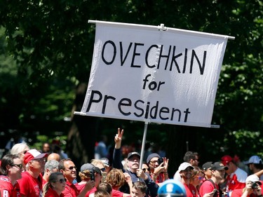 Fans hold a sign honouring Capitals star Alex Ovechkin as the team passes by Stanley Cup during the parade.