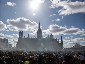 (FILES) In this file photo taken on April 20, 2018 Smoke lingers over Parliament Hill as people smoke marijuana during the annual 4/20 rally on Parliament Hill in Ottawa, Ontario.  Canada lawmakers voted to legalize cannabis on June 18, 2018.