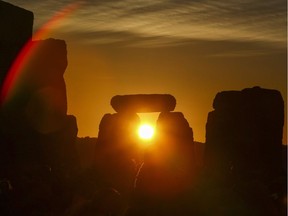 Revellers watch the sunrise as they celebrate the pagan festival of Summer Solstice at Stonehenge in Wiltshire, southern England on June 21, 2018. The festival, which dates back thousands of years, celebrates the longest day of the year when the sun is at its maximum elevation. Modern druids and people gather at the landmark Stonehenge every year to see the sun rise on the first morning of summer.