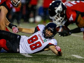 Redblacks receiver Brad Sinopoli can only watch as Stampeders defender Patrick Levels, right, picks up the ball after Sinopoli fumbled in the fourth quarter of Thursday's game. Al Charest/Postmedia