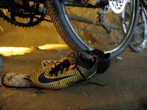 A pair of soccer shoes are left next to bicycles from a group of missing boys at the entrance of a deep cave in Chiang Rai, northern Thailand, Monday, June 25, 2018. (Thai News Pix via AP)