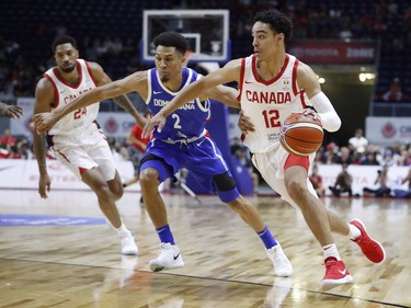 Canada's Andrew Nembhard goes to the basket against Dominican Republic's Rigoberto Mendoza De La Rosa, centre, during Friday's game in Toronto.