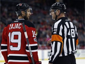 This 2017 file photo shows New Jersey Devils centre Travis Zajac, left, talking to referee Garrett Rank.