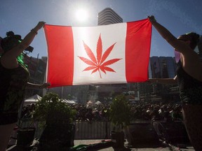 Two people hold a modified design of the Canadian flag with a marijuana leaf in in place of the maple leaf during the "420 Toronto" rally in Toronto, April 20, 2016.