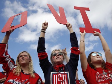 Olivia Spicer, 16, left, Emma Jacobs, 17, and Caroline Schwartz, 18, all of Gainesville, Va., hold up letters spelling the nickname of Capitals star Alex Ovechkin on the National Mall ahead of Tuesday's parade and rally.