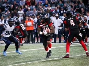 Redbacks running back Cedric O’Neal carries the ball and tries to elude Toronto Argonauts defensive lineman Troy Davis (92) during CFL pre-season action in Guelph on Thursday night. Mark spowart/The Canadian Press