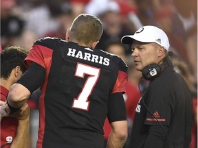 Redblacks head coach Rick Campbell talks with quarterback Trevor Harris as he leaves the field after a collision during the first quarter of Thursday's pre-season home game against the Alouettes. The Redblacks won the game 27-7.