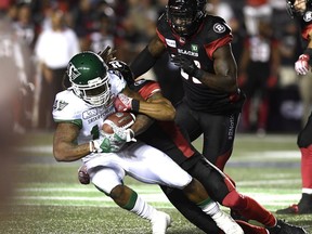 Ottawa Redblacks' Rico Murray (3) tackles Saskatchewan Roughriders' Tre Mason (10) during second half CFL action in Ottawa on Thursday, June 21, 2018.