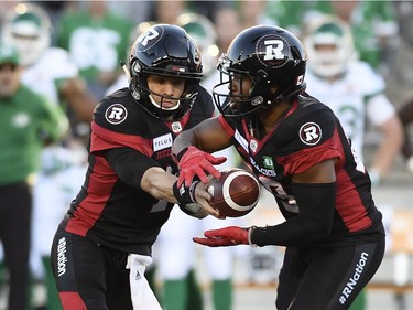 Ottawa Redblacks' Trevor Harris (7) plays the ball to William Powell (29) during first half CFL action against the Saskatchewan Roughriders in Ottawa on Thursday, June 21, 2018.