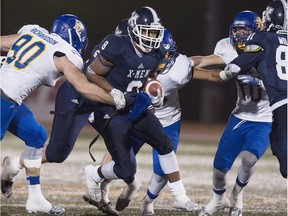 St. FX running back Ashton Dickson scrambles with the ball against UBC defenders during the Uteck Bowl national university football semifinal at Antigonish, N.S. on Nov. 21, 2015.