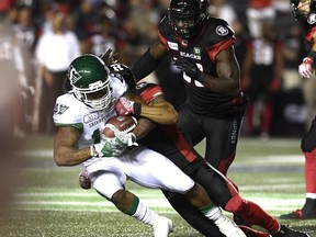 Ottawa Redblacks' Rico Murray (3) tackles Saskatchewan Roughriders' Tre Mason (10) during second half in Ottawa on Thursday, THE CANADIAN PRESS/Justin Tang