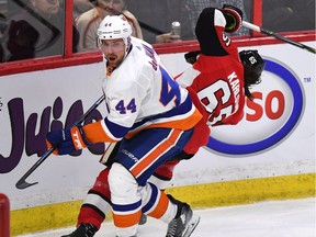 New York Islanders' Calvin de Haan (44) checks Ottawa Senators' Erik Karlsson (65) into the boards during first period NHL hockey action in Ottawa, Saturday November 25, 2017.