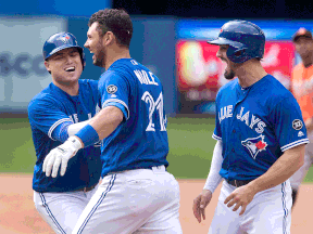 Toronto Blue Jays' Luke Maile celebrates his bases loaded walk-off RBI walk to defeat the Baltimore Orioles with teammates Randal Grichuk, right, and Aledmys Diaz in the 10th inning of their American League MLB baseball game in Toronto on Saturday June 9, 2018.