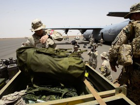 The first Canadian troops arrive and are helped to load bags by their German counterparts at a UN base in Gao, Mali, on Sunday, June 24, 2018.