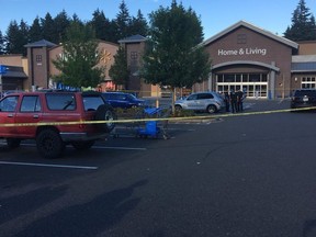 Police officers investigate the scene of a deadly shooting at a Walmart store in Tumwater, Wash., Sunday, June 17, 2018. A gunman wounded a few people before being fatally shot by a bystander at the store in Washington state's city Sunday evening. (KOMO News via AP)