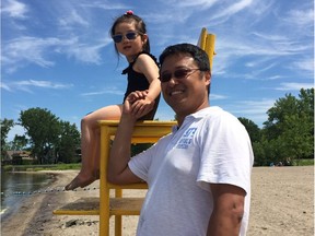 Jason Ding and his daughter, Julianna, soak up the sun at Britannia Beach on Saturday. Joanne Laucius/Postmedia