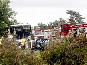 Firefighters help passengers off a bus involved in a serious collision west of Prescott on Highway 401 on Monday, June 4, 2018 near Prescott, Ont.