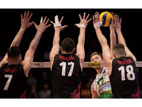 Paul Carroll of Australia into the Canadian wall formed by Stephen Timothy Maar, left, Graham Vigrass, middle, and Bradley Robert Gunter. Wayne Cuddington/Postmedia