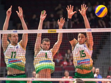 Australia tries to form a wall of blockers at the net with, left to right, Paul Carroll, Beau Graham and Luke Smith. Wayne Cuddington/Postmedia