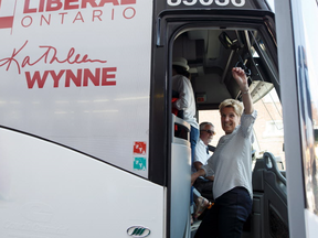 Ontario Liberal Party Leader Kathleen Wynne waves as she boards her bus following a campaign stop at a west end Toronto street festival on Saturday, June 2, 2018 in Toronto, Ontario. THE CANADIAN PRESS/Cole Burston