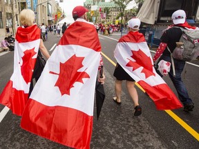 Revellers walk along Wellington St. during Canada Day celebrations in downtown Ottawa Saturday, July 1, 2017.