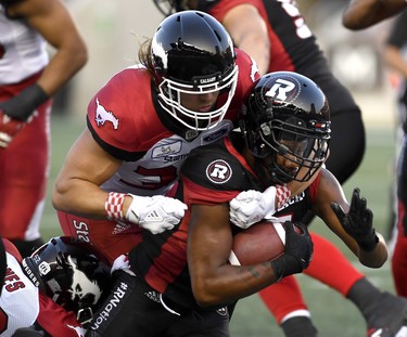 Ottawa Redblacks' Loucheiz Purifoy is tackled by Calgary Stampeders Ante Milanovic-Litre during Thursday's game.