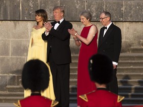 From left, U.S. first lady Melania Trump, President Donald Trump, British Prime Minister Theresa May, and her husband Philip May, watch the arrival ceremony at Blenheim Palace, in Blenheim, England, Thursday, July 12, 2018.