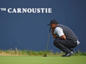Tiger Woods lines up a putt on the 18th green during his third round of the Open Championship at Carnoustie on Saturday.
