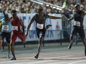 Aaron Brown checks out the competition to his left as he crosses the finish line at the Terry Fox Athletic Facility on Friday night.