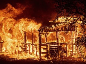 A structure burns as the Carr Fire races along Highway 299 near Redding, Calif., on Thursday, July 26, 2018.