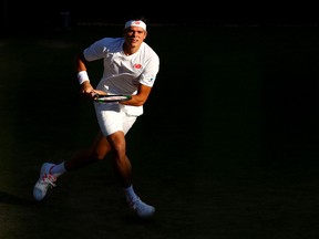 Milos Raonic waits to return a shot against John Isner at Wimbledon on July 11.