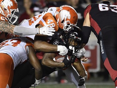 Redblacks tailback William Powell (29) runs the ball against Lions defenders Maxx Forde (48) and Jordan Herdman (53) during second-half action.
