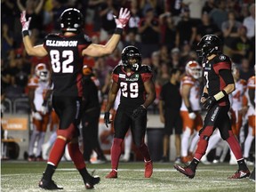Redblacks running back William Powell (29) celebrates his 25-yard catch-and-run play late in the fourth quarter with Greg Ellingson (82) and quarterback Trevor Harris (7).