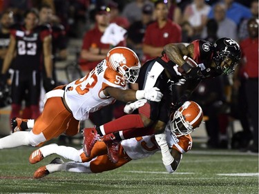 Redblacks wide receiver R.J. Harris (84) tries to leap past the tackles by Lions defenders Jordan Herdman (53) and Winston Rose.