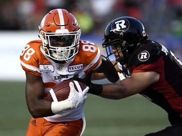 Lions receiver Shaq Johnson (88) protects the ball as the Redblacks' Antoine Pruneau tries to tackle him in the first half.