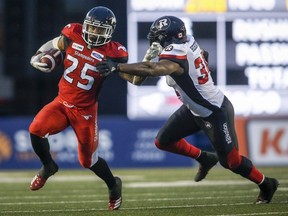 Ottawa Redblacks' Kyries Hebert, right, grabs for Calgary Stampeders' Don Jackson, during second half CFL football action in Calgary, Thursday, June 28, 2018.
