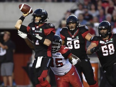 Ottawa Redblacks quarterback Trevor Harris (7) tries to avoid Calgary Stampeders Ja'Gared Davis (95) during first half CFL action in Ottawa on Thursday, July 12, 2018.