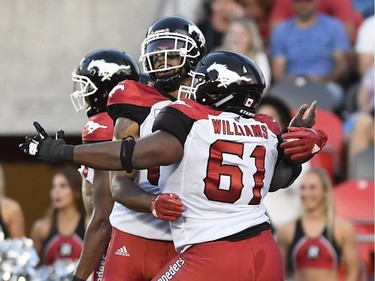 Calgary Stampeders Juwan Brescacin (82) celebrates his touchdown with Ucambre Williams (61) during first half CFL action in Ottawa on Thursday, July 12, 2018.