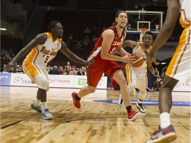 Canada's Kelly Olynyk (9) fines room in the lane against U.S. Virgin Islanders defenders. Errol McGihon/Postmedia