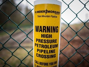 A sign warning of an underground petroleum pipeline is seen on a fence at Kinder Morgan's facility where work is being conducted in preparation for the expansion of the Trans Mountain Pipeline, in Burnaby, B.C., on April 9, 2018.