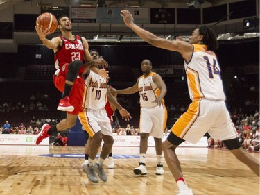 Canada's Phil Scrubb, a former Carleton Ravens star, drives the basket against U.S. Virgin Islands' Nicholas Claxton (14) during the first quarter of Monday's game at TD Place arena. Errol McGihon/Postmedia