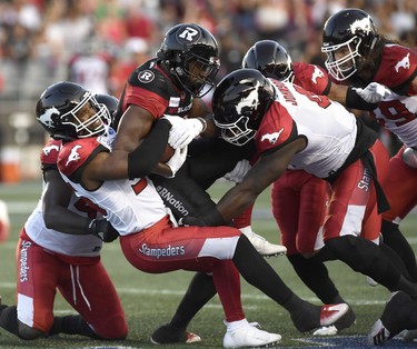 Ottawa Redblacks William Powell (29) gets tackled by Calgary Stampeders Jameer Thurman (56) during first half CFL action in Ottawa on Thursday, July 12, 2018. (THE CANADIAN PRESS/Justin Tang)