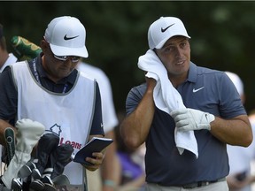 Francesco Molinari, right, towels off on the eighth tee box during the final round of the Quicken Loans National on Sunday.