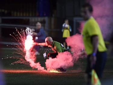 A security guard picks up a flare that was thrown onto the field during second half Canadian Championship soccer action between the Ottawa Fury FC and the Toronto FC, in Ottawa on Wednesday, July 18, 2018.
