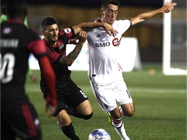 Ottawa Fury FC's Chris Mannella (5) battles for the ball with Toronto FC's Jay Chapman (14) during second half Canadian Championship soccer action in Ottawa on Wednesday, July 18, 2018.