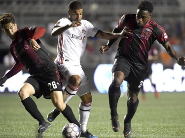 Toronto FC's Jordan Hamilton (22) battles for the ball with Ottawa Fury FC's Thomas Meilleur-Giguere (26) and Eddie Edward (3) during second half Canadian Championship soccer action in Ottawa on Wednesday, July 18, 2018.